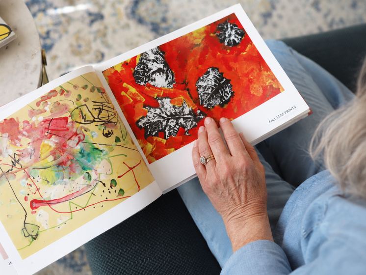 Grandparents paging through a Kids Art Book