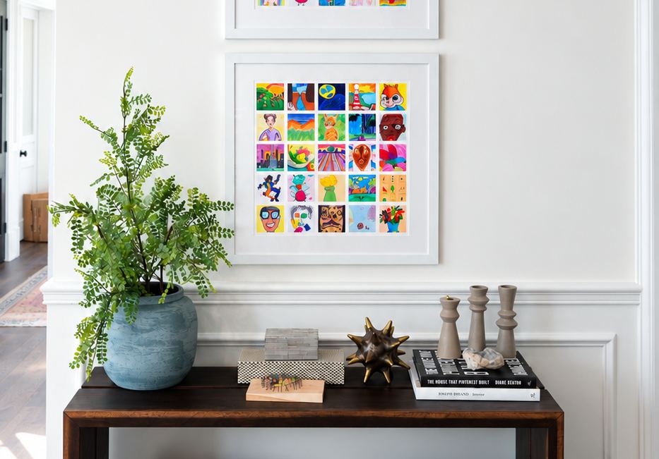 A framed mosaic of kids' art hanging above a console table